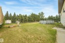 Fenced backyard featuring an above-ground pool and mature evergreen trees - 54 Buskmose Dr, Rural Wetaskiwin County, AB  - Outdoor 