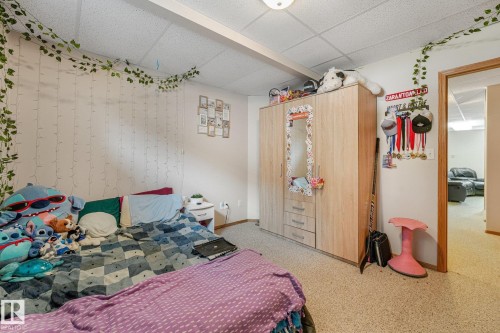 Carpeted bedroom featuring a built-in wardrobe with mirrored paneling - 54 Buskmose Dr, Rural Wetaskiwin County, AB - Indoor Photo Showing Bedroom
