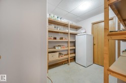 Utility room featuring extensive built-in shelving, a hard-surface floor, and a drop ceiling - 