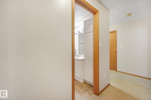 Bathroom vanity featuring a white cabinet, integrated sink, and wall-mounted light bar - 54 Buskmose Dr, Rural Wetaskiwin County, AB - Indoor Photo Showing Other Room