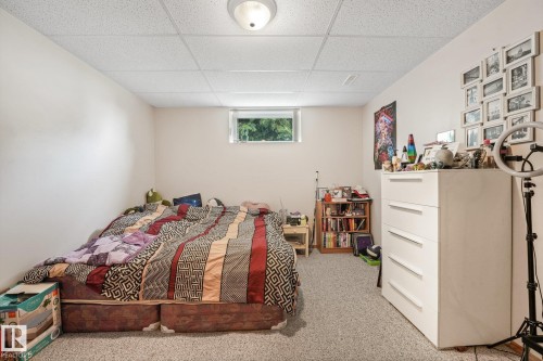 Carpeted room featuring a white drop ceiling with an overhead light fixture - 54 Buskmose Dr, Rural Wetaskiwin County, AB - Indoor Photo Showing Bedroom