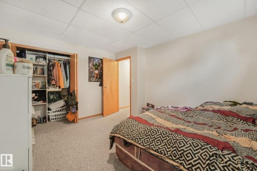 Bedroom with neutral-toned walls, gray carpet, and a white acoustical tile ceiling - 54 Buskmose Dr, Rural Wetaskiwin County, AB - Indoor Photo Showing Bedroom