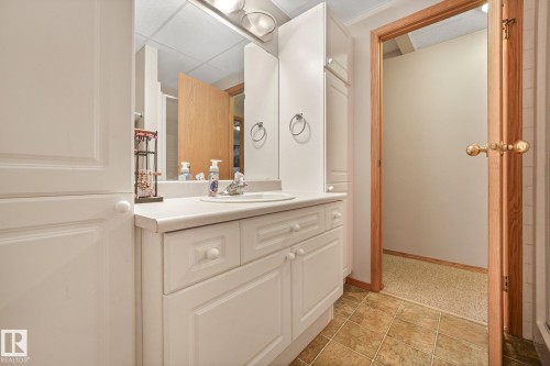 Bathroom vanity featuring white cabinetry, a single basin sink, and a light-toned countertop - 54 Buskmose Dr, Rural Wetaskiwin County, AB - Indoor Photo Showing Bathroom