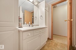 Bathroom vanity featuring white cabinetry, a single basin sink, and a light-toned countertop - 