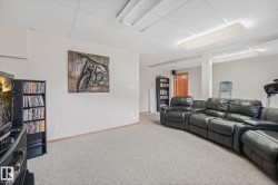 Carpeted room with a drop ceiling, white walls, and wood baseboards - 