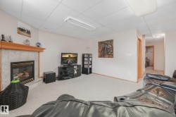 Carpeted interior space featuring a fireplace with a tile surround and wood mantel - 