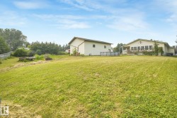 Expansive grassy yard with two detached structures - 