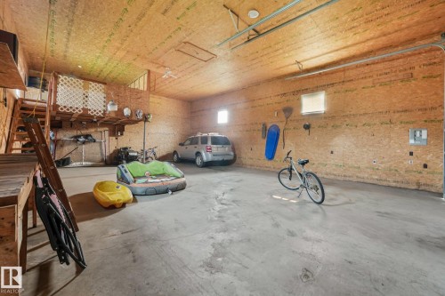 Spacious garage featuring a concrete floor, plywood walls, and a wood-finish ceiling - 54 Buskmose Dr, Rural Wetaskiwin County, AB - Indoor Photo Showing Garage
