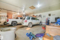 Spacious two-vehicle garage featuring a concrete floor, built-in shelving, and overhead lighting - 