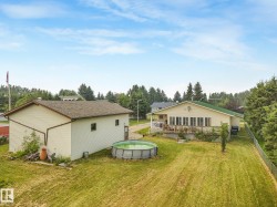 Expansive backyard featuring a large accessory building, above-ground pool, and a chain-link fence - 