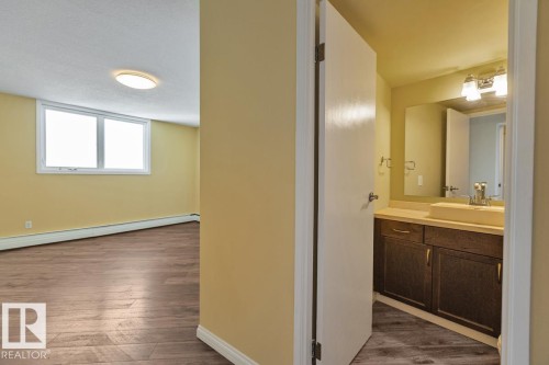 Room featuring wood-finish flooring, a window, and flush mount lighting - #1307 10045 117 St Nw, Edmonton, AB 