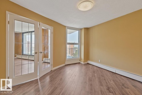 Wood-finish flooring, white trim throughout, and a flush mount ceiling light - #1307 10045 117 St Nw, Edmonton, AB 