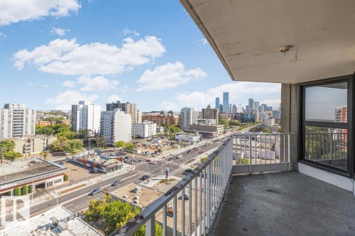 Private balcony with concrete flooring and metal railing, featuring expansive city skyline and urban street views - #1307 10045 117 St Nw, Edmonton, AB 