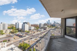 Private balcony with concrete flooring and metal railing, featuring expansive city skyline and urban street views - 