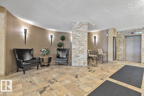 Tile flooring, stone accent walls, wall-mounted sconces, and an elevator - #1307 10045 117 St Nw, Edmonton, AB 