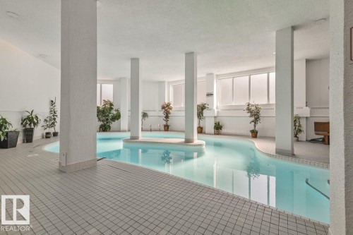 Indoor swimming pool with a meandering design, tiled surround, and integrated support columns - #1307 10045 117 St Nw, Edmonton, AB 