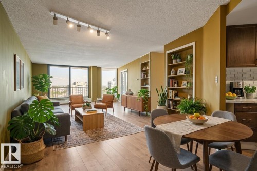 Expansive windows, wood-finish flooring, recessed built-in shelving, track lighting, and a partial kitchen with a subway tile backsplash - #1307 10045 117 St Nw, Edmonton, AB 