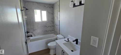 Vanity with a quartz countertop, integrated sink, and matte black faucet - 13812 63 Street Nw, Edmonton, AB 