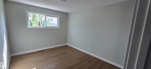 Wood-finish flooring, light grey wall paint, and a white-framed window - 13812 63 Street Nw, Edmonton, AB 