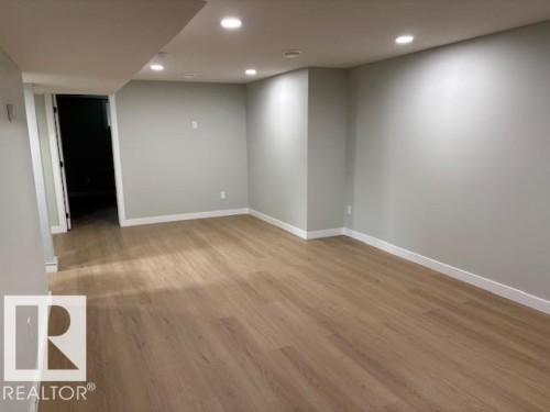 Recessed lighting illuminates the wood-finish flooring and light gray walls - 13812 63 Street Nw, Edmonton, AB 