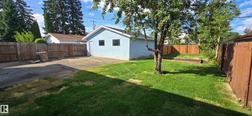 Detached garage with a stucco finish, two windows, and a side access door - 13812 63 Street Nw, Edmonton, AB 