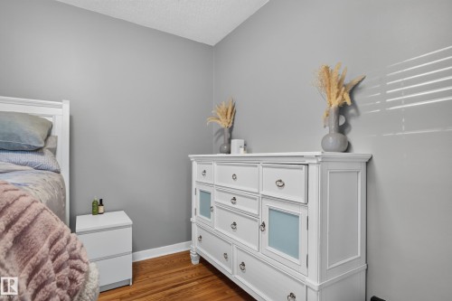 Wood-finish flooring with white baseboards and neutral wall tones - 11406 83 Street Nw, Edmonton, AB 