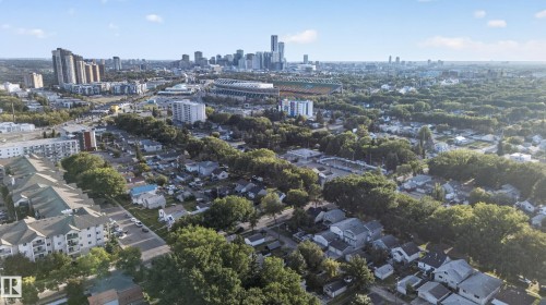 Expansive urban landscape featuring a distant skyline, substantial tree coverage, and varying residential and commercial structures - 11406 83 Street Nw, Edmonton, AB 