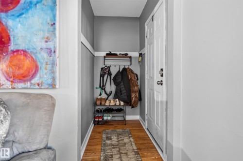 Wood-finish flooring with white trim, gray wall paint, and a white paneled door - 11406 83 Street Nw, Edmonton, AB 
