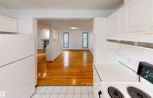 White cabinetry with an integrated range hood, white countertop, and tile flooring - 10941 81 Avenue Nw, Edmonton, AB 
