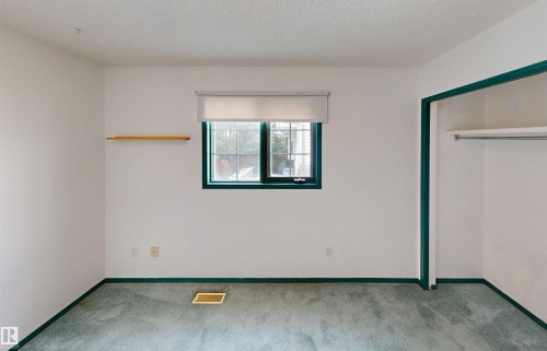 Recessed window with roller shade, wall-mounted shelving, and built-in closet with hanging rod and shelving - 10941 81 Avenue Nw, Edmonton, AB 