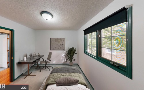 Recessed ceiling light fixture, casement windows with dark trim, wood-finish flooring, and a solid core interior door - 10941 81 Avenue Nw, Edmonton, AB 
