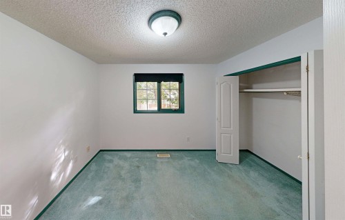 Recessed window with dark trim, overhead flush mount lighting, and built-in closet with bifold doors - 10941 81 Avenue Nw, Edmonton, AB 