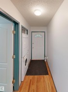 Hardwood flooring, front-loading washer and dryer, and an entry door with an arched transom window - 