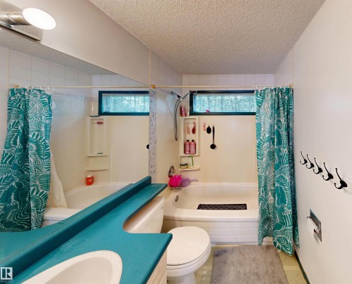Tub and shower combination with a glass block window and a built-in shelf - 10941 81 Avenue Nw, Edmonton, AB 