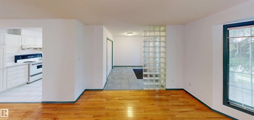 Wood-finish flooring, white walls, and a glass block architectural feature create a bright interior - 10941 81 Avenue Nw, Edmonton, AB 
