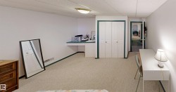 White walls with contrasting trim, light-toned carpeting, and built-in desk with an integrated counter - 