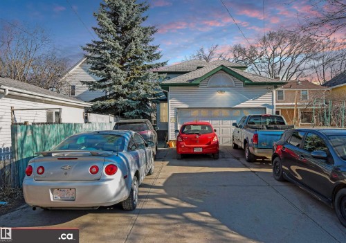 Detached garage with a paneled door, exterior wall light fixture, and horizontal siding - 10941 81 Avenue Nw, Edmonton, AB 
