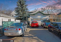 Detached garage with a paneled door, exterior wall light fixture, and horizontal siding - 