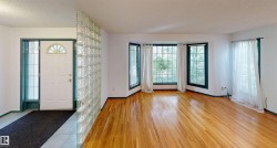 Entryway featuring a glass block partition, wood-finish flooring, and bay windows - 