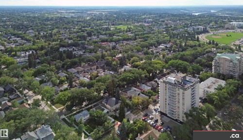 Expansive neighborhood with mature tree coverage, a high-rise building with multiple balconies, and a distant river - 10941 81 Avenue Nw, Edmonton, AB 