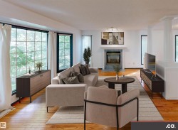 Hardwood flooring throughout, a large grid-pane window, a fireplace with a mantel, and architectural columns - 