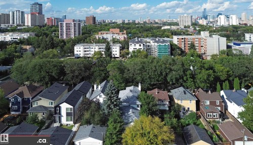Residential area featuring a mix of housing styles, abundant mature trees, and a distant cityscape - 10941 81 Avenue Nw, Edmonton, AB 