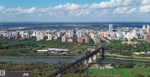 Expansive aerial perspective showcasing a vibrant urban landscape, a prominent river, a substantial bridge structure, and abundant green spaces - 10941 81 Avenue Nw, Edmonton, AB 