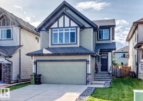 Two-story home with a gabled roof and light green siding - 5633 175A Avenue Nw, Edmonton, AB 