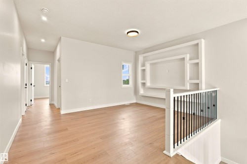 Light wood-finish flooring with white walls and trim throughout - 10458 104 Street, Morinville, AB 