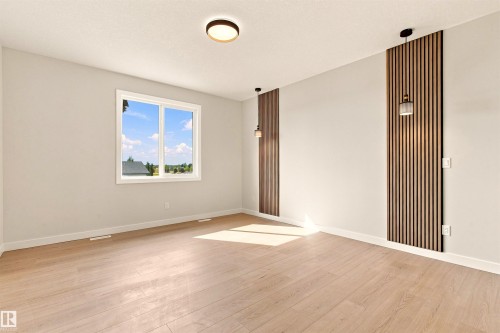Light wood-finish flooring with white baseboards, a flush-mount ceiling light, and a double-pane window - 10458 104 Street, Morinville, AB 