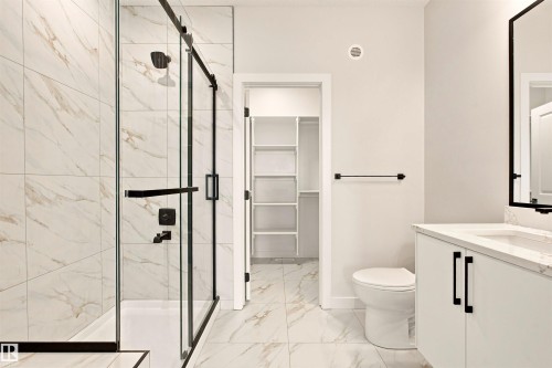 Full bathroom with walk-in shower, sliding glass shower door, and a single vanity with storage - 10458 104 Street, Morinville, AB 