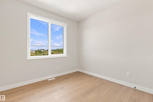 Wood-finish flooring, white trim, light gray walls, and a large window - 10458 104 Street, Morinville, AB 