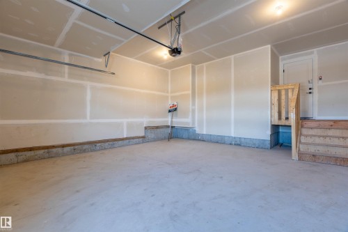 Concrete flooring, unfinished drywall, overhead lighting, garage door opener, interior access door - 10458 104 Street, Morinville, AB 
