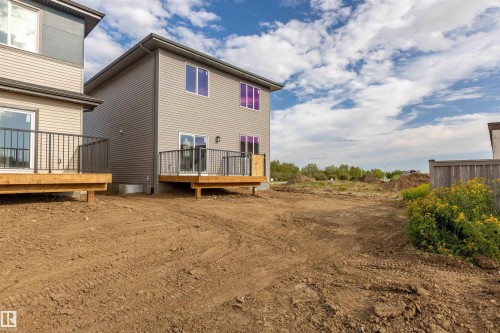 Rear exterior with light gray siding and multiple windows - 10458 104 Street, Morinville, AB 